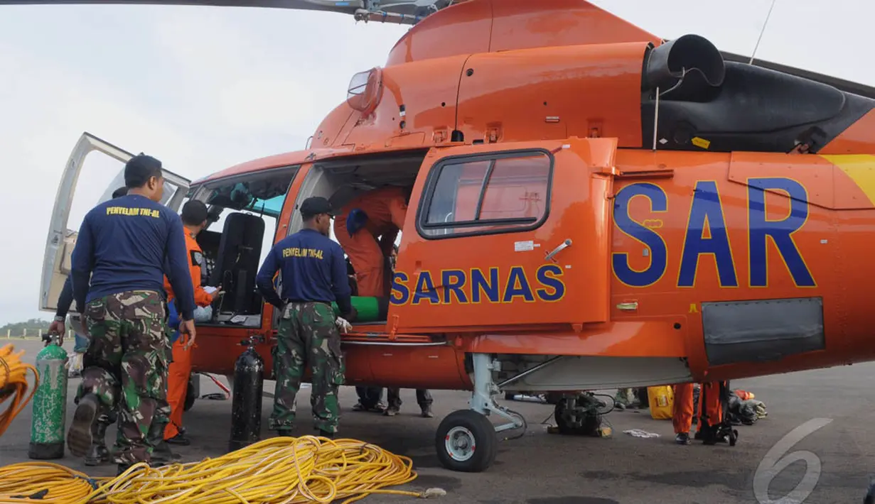 Penyelam TNI-AL memasukan perlengkapan untuk mengangkat ekor AirAsia ke dalam helikopter di Lanud Iskandar, Pangkalan Bun, Kalteng, Sabtu (10/1/2015).  (Liputan6.com/Andrian M Tunay)