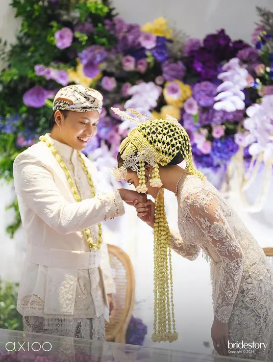 <p>Rizky Fabian tampak tersenyum cerah melihat Mahalini mencium tangannya usai resmi menjadi suami istri. (Foto: Instagram/ axioo)</p>