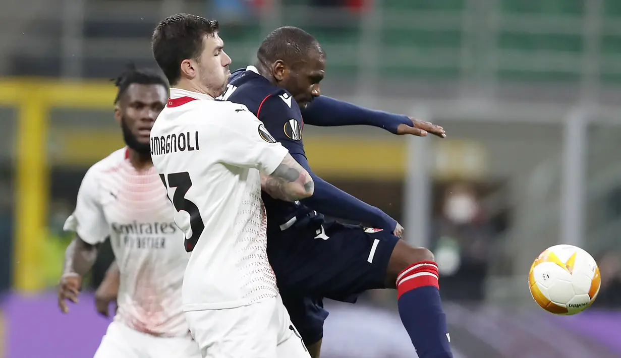 Striker Red Star Belgrade, El Fardou Nabouhane (kanan) melepaskan tendangan dibayangi bek AC Milan, Alessio Romagnoli dalam laga leg kedua babak 32 Besar Liga Europa 2020/21 di San Siro Stadium, Kamis (25/2/2021). Red Star Belgrade bermain Imbang 1-1 dengan AC Milan. (AP/Antonio Calanni)