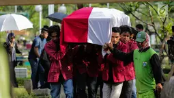Sejumlah mahasiswa mengangkat peti jenazah Benny Soemarno saat akan dimakamkan di TPU Karet Bivak, Jakarta, Senin (2/4). Benny Soemarno meninggal pada usia 68 tahun. (Liputan6.com/Faizal Fanani)
