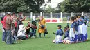 Orang tua mengabadikan momen saat anak-anak mereka mengikuti coaching clinic di Lapangan ABC Senayan, Jakarta, Rabu (28/3/2018). Acara ini dalam rangkaian peluncuran Patriot 165 FC. (Bola.com/Asprilla Dwi Adha)