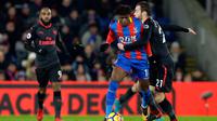 Pemain Arsenal, Calum Chambers berusaha menahan pemain Crystal Palace Wilfried Zaha saat pertandingan Liga Inggris di stadion Selhurst Park di London (28/12). (AP Photo/Alastair Grant)