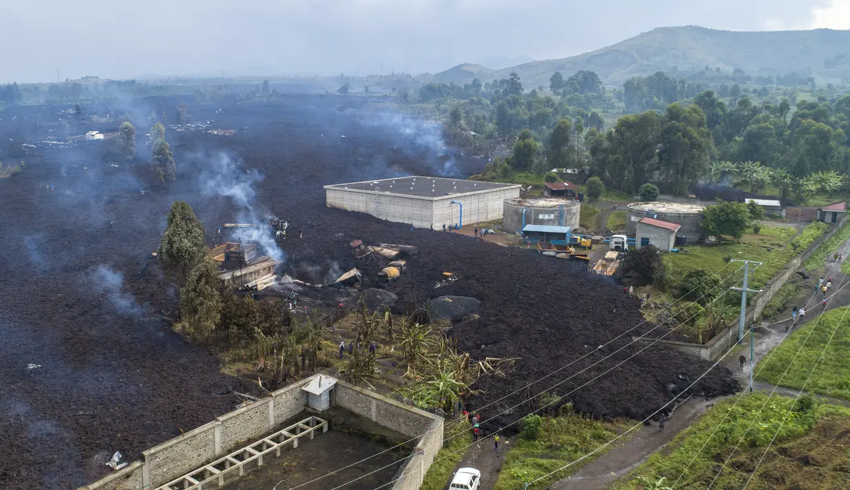 Lava dari letusan Gunung Nyiragongo membelah Buhene di utara Goma, Kongo (24/5/2021). Penduduk kembali ke rumah yang hancur dan mencari orang yang dicintai yang hilang di pinggiran Goma setelah gunung berapi besar itu meletus Sabtu 22 Mei 2021. (AP Photo/Justin Kabumba)