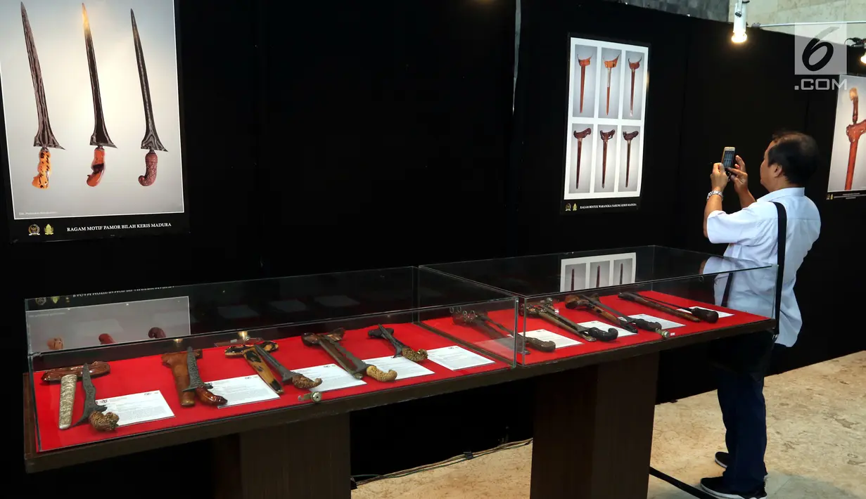 Pengunjung mengambil gambar koleksi keris saat Pameran Keris Madura di Gedung Nusantara, Kompleks Parlemen Senayan, Jakarta, Kamis (21/3). Pameran ratusan keris itu untuk mengajak masyarakat mencintai seni dan budaya nusantara. (Liputan6.com/Johan Tallo)