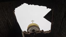 Sebuah lubang di atap sebuah gereja yang rusak, di Lukashivka, dekat kota Chernihiv di Ukraina utara,  22 April 2022. Penduduk mengatakan tentara Rusia menggunakan rumah ibadah untuk menyimpan amunisi, dan pasukan Ukraina menembaki gedung itu untuk membuat Rusia pergi. (AP Photo/Petros Giannakouris)