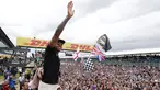 Pembalap Formula 1, Lewis Hamilton merayakan kemenangan bersama pengemarnya usai berlaga di Grand Prix Formula 1 Silverstone di Inggris, (5/7/2015). Hamilton berhasil finish di urutan pertama dengan waktu 1 jam 31 menit 27,729 detik. (Reuters/Hoch Zwei)