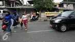 Pejalan kaki menyeberang meski terdapat tulisan agar tidak menyeberang sembarangan di jalan raya Lenteng Agung, Jakarta (3/12). Ironisnya, tak jauh dari lokasi terdapat Jembatan Penyeberangan Orang (JPO) yang masih berfungsi. (Liputan6.com/Yoppy Renato)