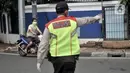 Petugas memberhentikan pengendara sepeda motor tanpa perlengkapan saat penindakan Pembatasan Sosial Berskala Besar (PSBB) di kawasan Menteng, Jakarta, Senin (13/4/2020). (merdeka.com/Iqbal S. Nugroho)
