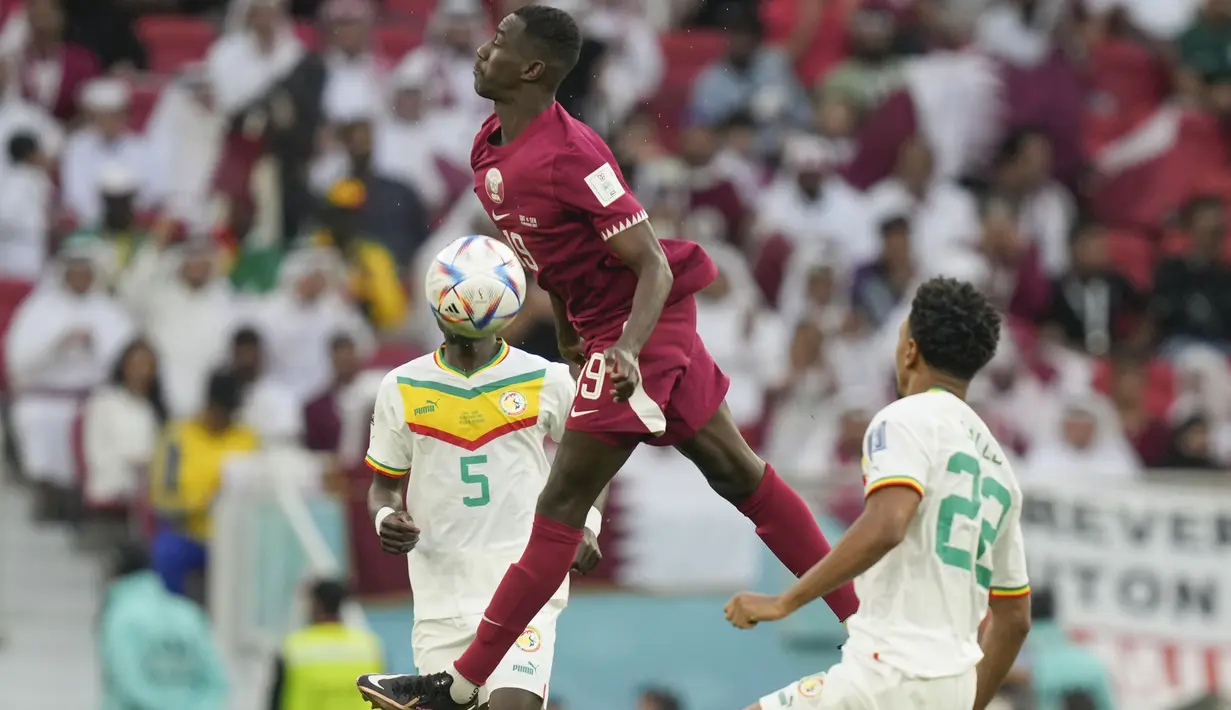 Penyerang Qatar, Almoez Ali mengontrol bola dari kawalan pemain Senegal, Idrissa Gueye dan Abdou Diallo selama pertandingan grup A Piala Dunia 2022 di Stadion Al Thumama di Doha, Qatar, Jumat (25/11/2022). Berkat kemenangan 3-1, Senegal menjaga harapan lolos ke babak 16 besar. (AP Photo/Darko Bandic)