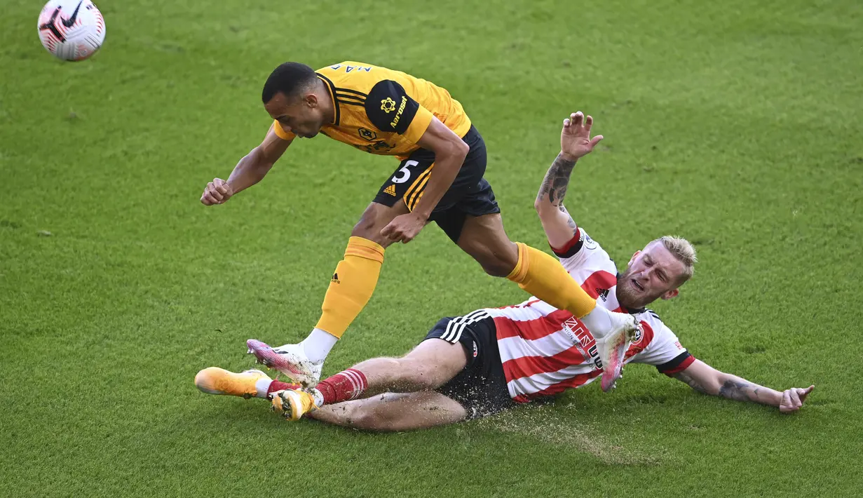 Pemain Sheffield United, Oliver McBurnie berusaha merebut bola dari pemain Wolverhampton Wanderers, Fernando Marcal pada pertandingan Liga Inggris di stadion Bramall Lane, Inggris, Senin, (14/9/2020). Wolves menang 2-0 atas Sheffield United. (Laurence Griffiths/Pool via AP)