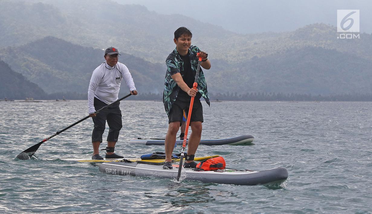 Direktur Utama Ketenagakerjaan, Agus Susanto dan Bupati Trenggalek, Mochammad Nur Arifin olah raga  Stand Up Paddle di Pantai Mutiara, Trenggalek, Jawa Timur, Sabtu (7/9/2019). (Liputan6.com/Herman Zakharia)