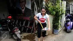 Gadis Ahok terlihat membersihkan sampah di kawasan Cipete, Jakarta Selatan, Senin (26/12). Aksi ini dilakukan agar masyarakat di Jakarta bisa lebih peduli lagi tentang pentingnya kebersihan lingkungan tempat tinggalnya. (Liputan6.com/Gempur M Surya)