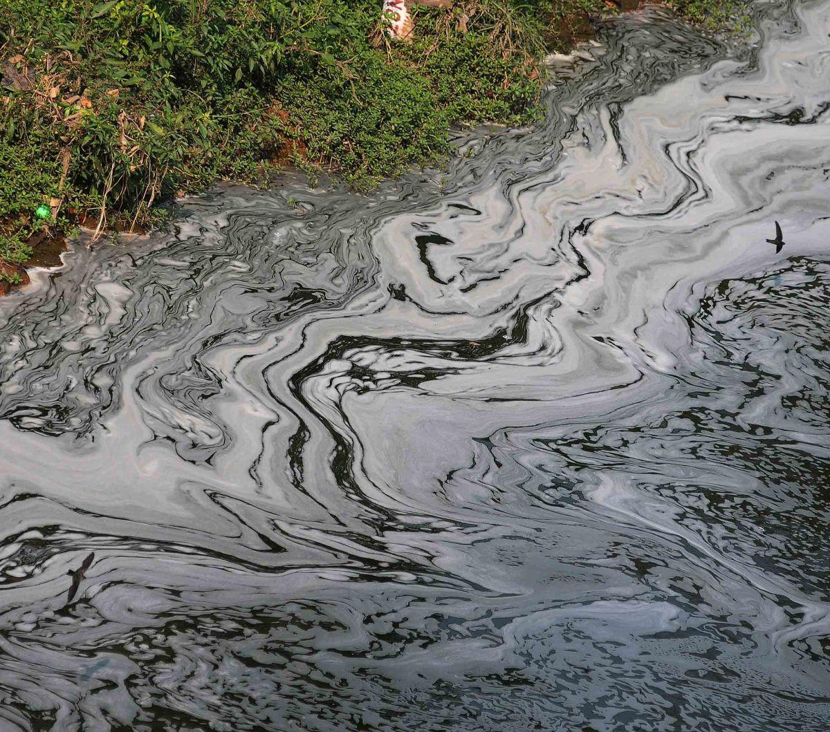 Kemunculan busa putih terlihat pada aliran Kanal Banjir Timur (KBT) yang keluar dari pintu air Malaka Sari, Jakarta, Selasa (22/8/2023).