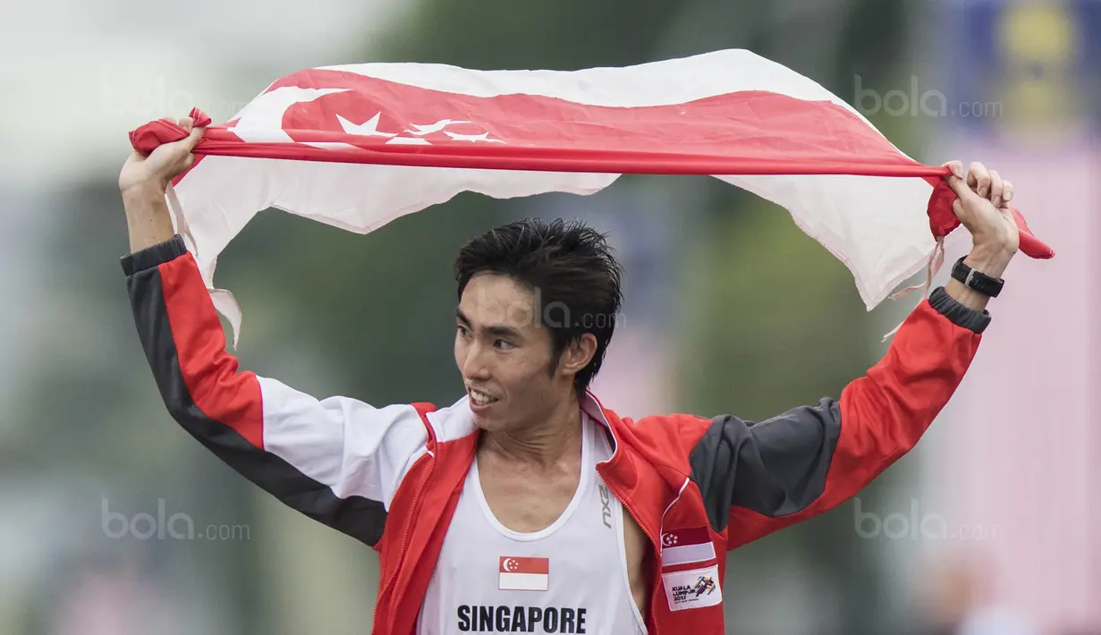 Pelari Singapura, Soh Rui Yong, melakukan selebrasi usai tampil pada nomor marathon SEA Games di Putrajaya, Kuala Lumpur, Sabtu (19/8/2017). Soh meraih medali emas dengan waktu dua jam 24 menit 55 detik. (Bola.com/Vitalis Yogi Trisna)