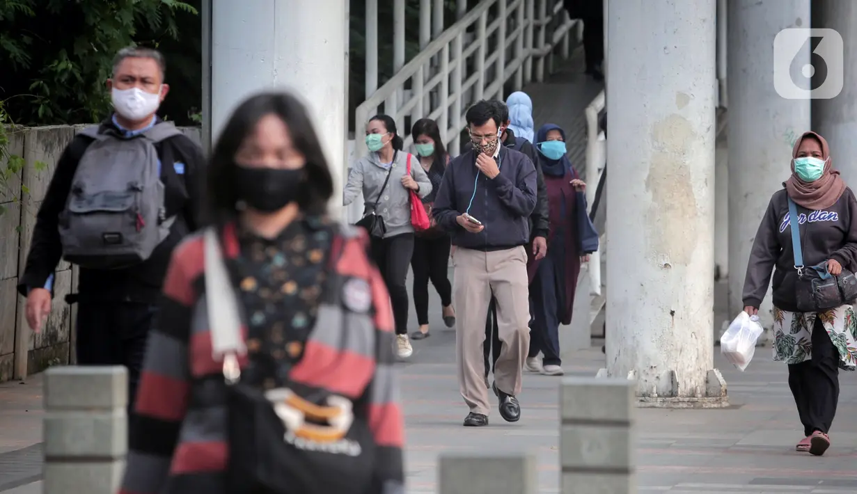 Pegawai pulang kerja berjalan di trotoar Jalan Sudirman, Jakarta, Selasa (12/5/2020). Pemerintah memberi kelonggaran bergerak bagi warga berusia di bawah 45 tahun untuk mengurangi angka pemutusan hubungan kerja (PHK) akibat pandemi virus corona COVID-19. (Liputan6.com/Johan Tallo)