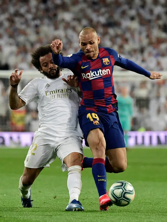 Pemain Barcelona, Martin Braithwaite (kanan) berebut bola dengan bek Real Madrid, Marcelo pada lanjutan pertandingan La Liga di Santiago Bernabeu, Minggu (2/3/2020).  Real Madrid membungkam Barcelona 2-0 dan merebut puncak klasemen dari Barcelona. (JAVIER SORIANO/AFP)
