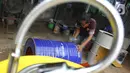 Perajin memproduksi wastafel portabel berbahan baku drum di workshop Galuh Creatives, Tangerang Selatan, Sabtu (30/5/2020). Wacana pemerintah menerapkan tatanan normal baru berimbas pada meningkatnya pesanan wastafel portabel untuk kebutuhan masyarakat di wilayah Jabotabek. (merdeka.com/Arie Basuki)