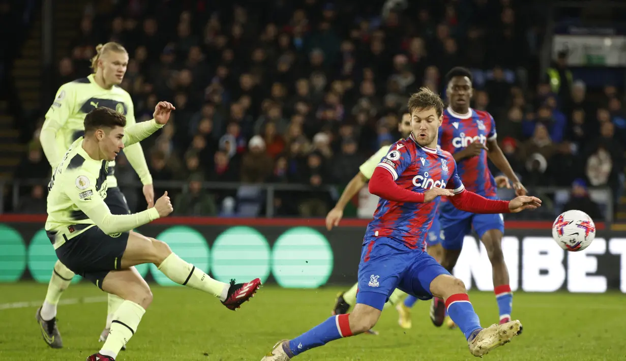 Penyerang Manchester City, Julian Alvarez menendang bola dari kawalan pemain Crystal Palace, Joachim Andersen pada pertandingan lanjutan Liga Inggris di stadion Selhurst Park, di London, Minggu (12/3/2023). Manchester City menang atas Crystal Palace dengan skort tipis 1-0. (AP Photo/David Cliff)