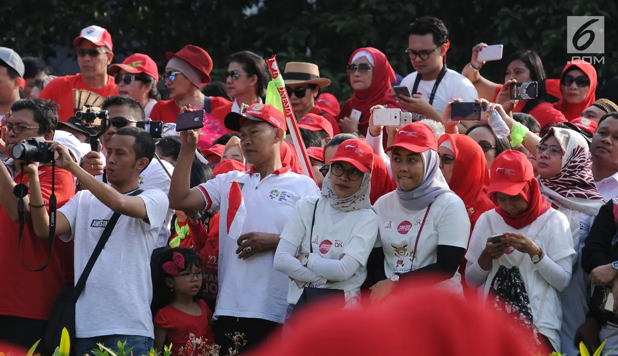 Sejumlah peserta Harmoni Indonesia 2018 mengabadikan moment saat gelaran di Kompleks Gelora Bung Karno, Jakarta, Minggu (5/8). Acara ini bagian perayaan HUT RI ke-73 dan menyambut Asian Games 2018. (Liputan6.com/Helmi Fithriansyah)