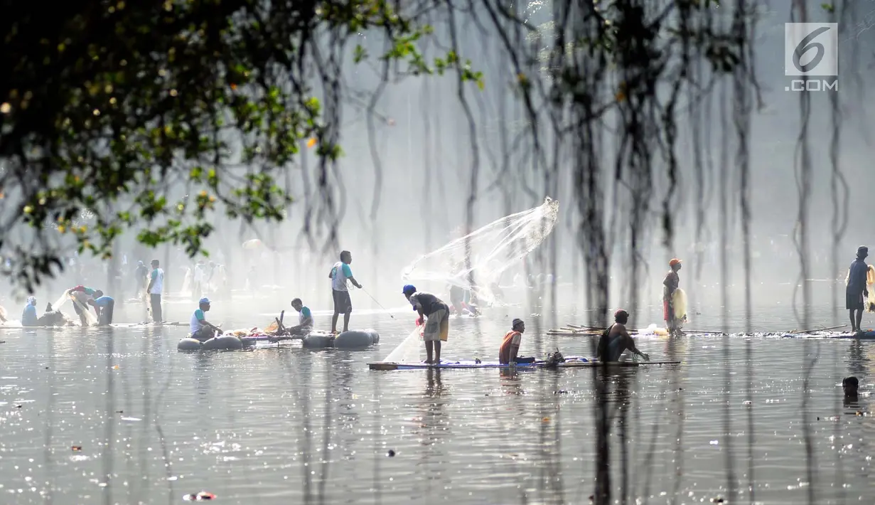 Warga menjala ikan saat tradisi Ngubek Situ di Situ Gede, Bogor, Minggu (13/5). Pesta rakyat ini digelar dalam rangka ‘mapag munggah’ atau menyambut datangnya bulan Ramadhan 1439 H. (Merdeka.com/Arie Basuki)