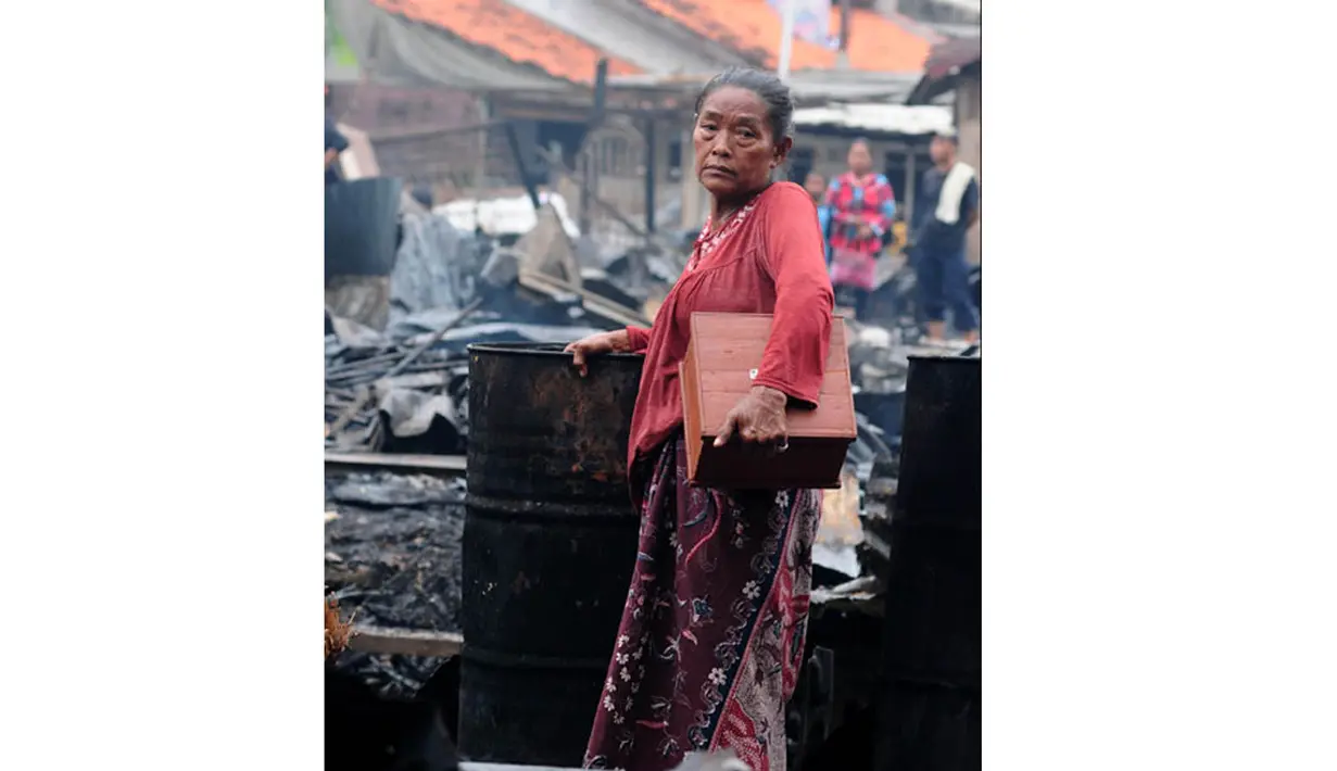 Seorang ibu tak kuasa menahan kesedihan melihat rumahnya ikut terbakar oleh si jago merah. (Liputan6.com/Andrian M Tunay)