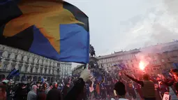 Suporter Inter Milan merayakan dan meneriakkan slogan-slogan di alun-alun Piazza Duomo di depan katedral gotik di Milan, Italia, Minggu (2/5/2021). Perolehan 84 poin, Inter Milan sudah tak dapat dikejar tim lain. (AP Photo/Luca Bruno)
