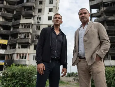 Mantan striker dan pelatih tim nasional sepak bola Ukraina Andriy Shevchenko (kiri) bersama aktor Amerika Serikat Liev Schreiber berdiri di depan sebuah rumah yang telah dihancurkan oleh pemboman Rusia di Borodianka, dekat Kyiv, Ukraina, 15 Agustus 2022. Andriy Shevchenko merupakan duta besar platform penggalangan dana UNITED24 yang diluncurkan oleh Presiden Ukraina Volodymyr Zelenskyy sebagai tempat utama untuk mengumpulkan sumbangan amal untuk mendukung Ukraina. (AP Photo/Evgeniy Maloletka)