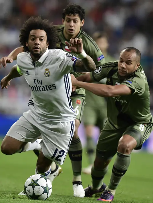 Bek Real Madrid, Marcelo berusaha membawa bola dari kejaran gelandang Vadis Odjidja-Ofoe pada Liga Champion di stadion Santiago Bernabeu, Spanyol, (18/10). Madrid menang telak atas Legia dengan skor 5-1. (AFP Photo/JAVIER Soriano)