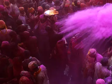 Peserta menaburkan bubuk berwarna selama perayaan Lathmar Holi di Barsana, Uttar Pradesh, India (6/3). Lathmar Holi adalah festival yang dirayakan sebelumnya Holi sebenarnya digelar. (AFP Photo/STR)