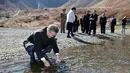 Presiden Korea Selatan Moon Jae-in memasukkan air kawah ke dalam botol di Gunung Paektu, Korea Utara, Kamis (20/9). Gunung Paektu merupakan gunung berapi yang dianggap sakral di Korea Utara. (Pyongyang Press Corps Pool via AP)