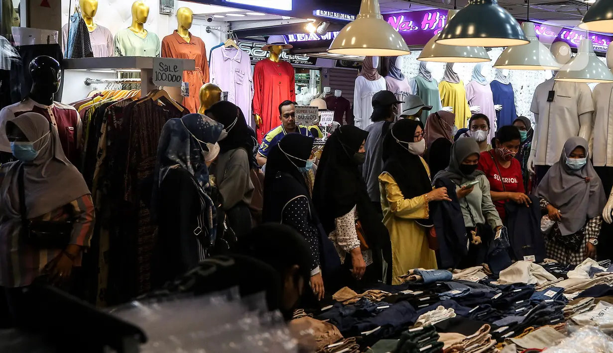 Warga memilih pakaian di Pasar Tanah Abang, Jakarta, Selasa (6/4/2021). Menjelang bulan Ramadan, Pasar Tanah Abang mulai dipadati pengunjung untuk berbelanja busana, namun menurut pedagang jumlah pengunjung bulan Ramadan kali ini tidak seramai sebelum pandemi Covid-19. (Liputan6.com/Johan Tallo)