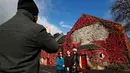 Wisatawan berpose di dekat Blair Athol Distillery, Skotlandia, Selasa (18/10). Blair Athol Distillery adalah kawasan objek wisata dengan bangunan unik karena ditumbuhi tumbuhan merambat berwarna merah.( REUTERS / Russell Cheyne)