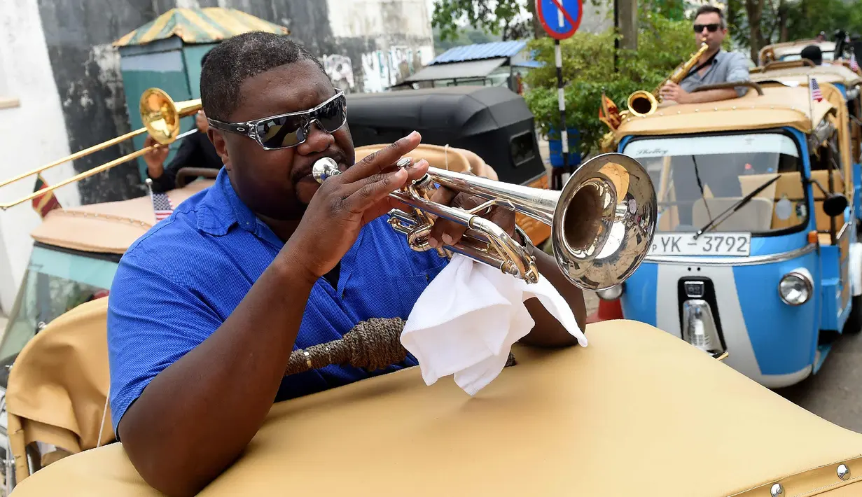 Musisi jazz AS, Wycliffe Gordon memainkan terompet dalam pertunjukan jalanan di ibukota Sri Lanka, Kolombo (26/2). Dalam pertunjukkan unik tersebut Wycliffe menggunakan tuk tuk untuk menghibur warga Sri Lanka. (AFP Photo/Ishara S. Kodikara)