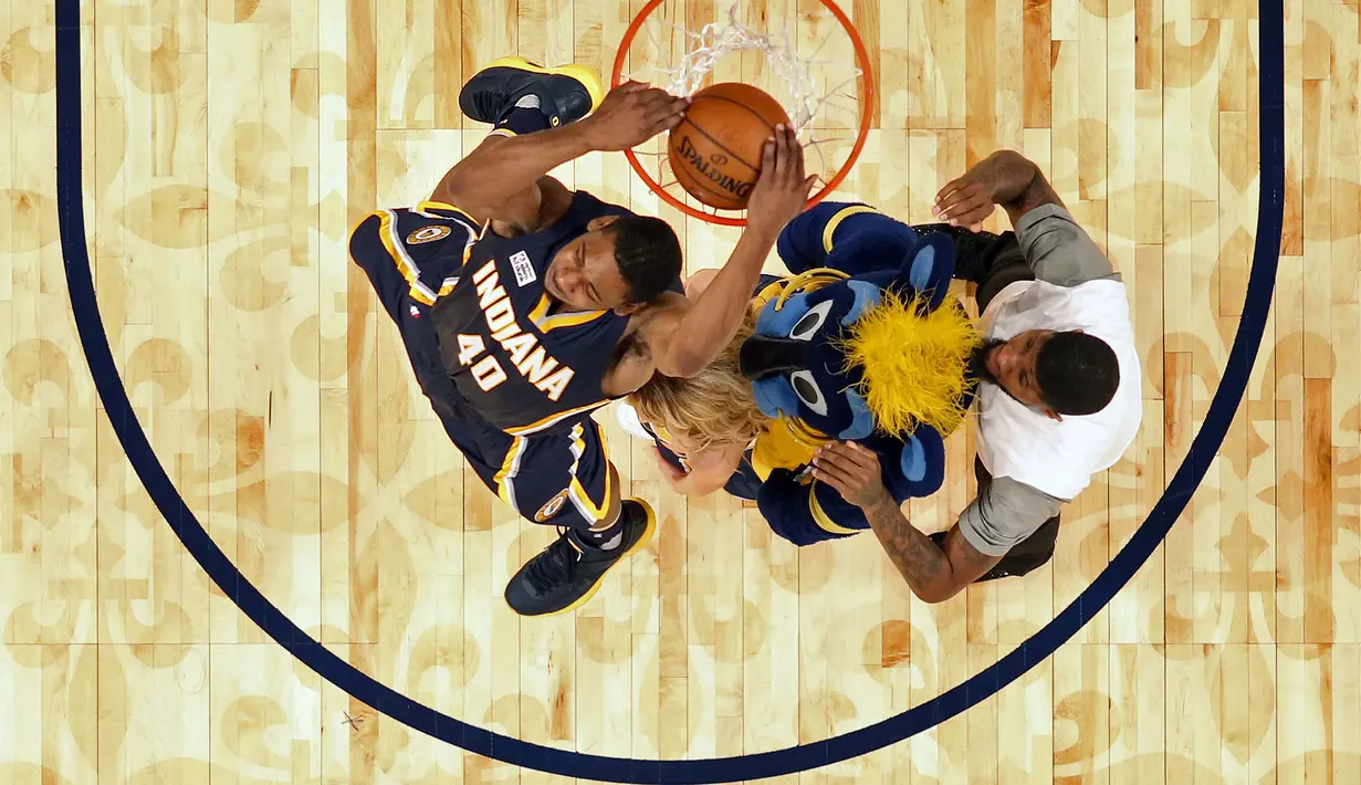 Ekspresi pemain Indiana Pacers, Glenn Robinson III saat melakukan slam dunk melewati rekannya Paul George, Maskot dan   seorang cheerleader pada ajang NBA All-Star Saturday Night di New Orleans, (18/2/2017).  (AP/Gerald Herbert)