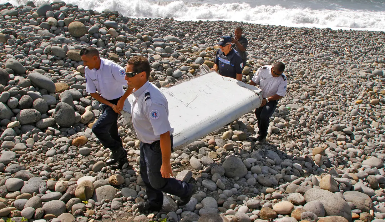 Foto ini diambil pada tanggal 29 Juli 2015, Polisi Perancis membawa potongan puing-puing dari pesawat yang diduga Malaysia Airlines MH370 di pantai Saint-Andre, Pulau Reunion. (AP Photo/Lucas Marie)