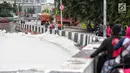 Warga melihat kondisi Kali Item yang berbusa di Kemayoran, Jakarta, Selasa (1/1). Tumpukan busa menjadi tontonan warga yang melintas. (Liputan6.com/Faizal Fanani)