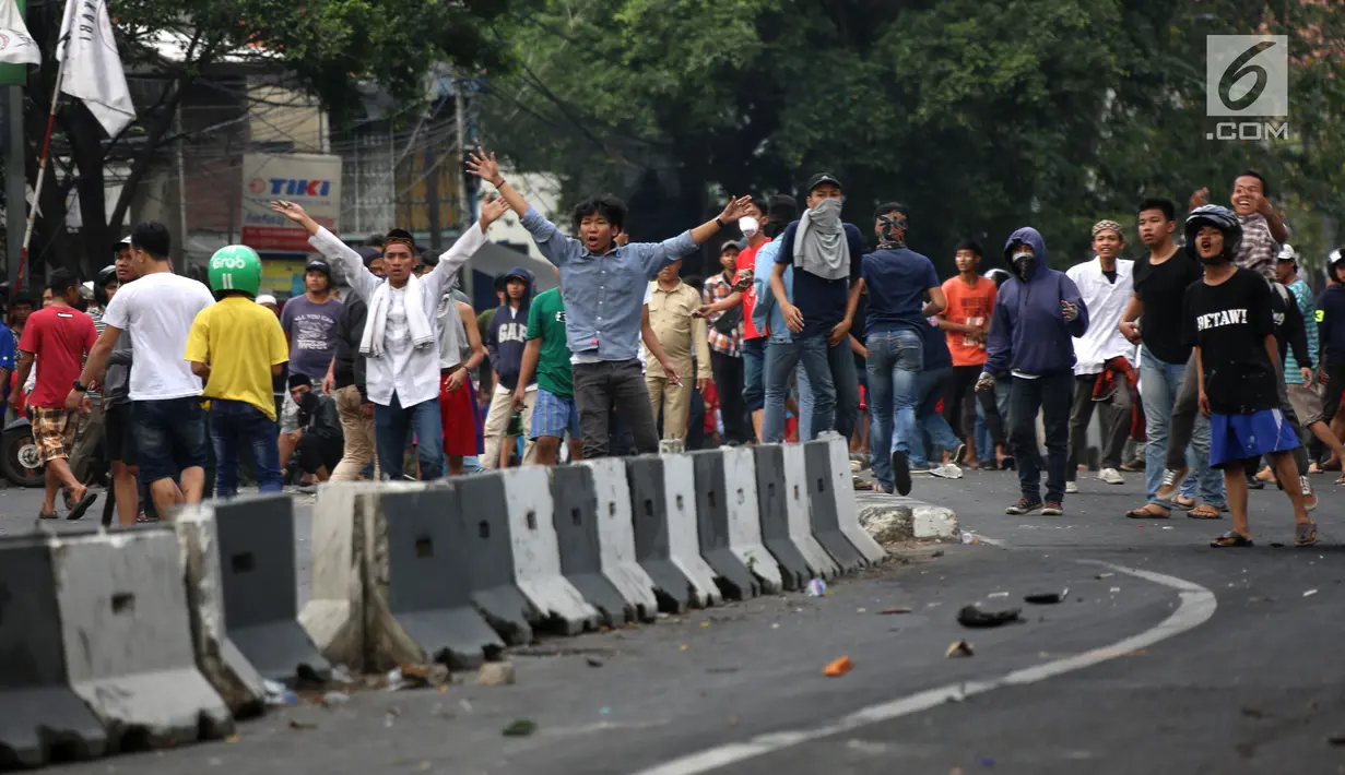 Massa berkerumun saat terjadi bentrok dengan aparat keamanan di kawasan Slipi, Jakarta Barat, Rabu (22/5/2019). Polisi membalas lemparan batu para pengunjuk rasa dengan menembakkan gas air mata. (Liputan6.com/Gempur Muhammad Surya)