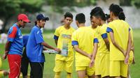 Asisten pelatih Arema U-21, Noordin Bastyan, memberikan instruksi pada para pemain. (Bola.com/Iwan Setiawan)