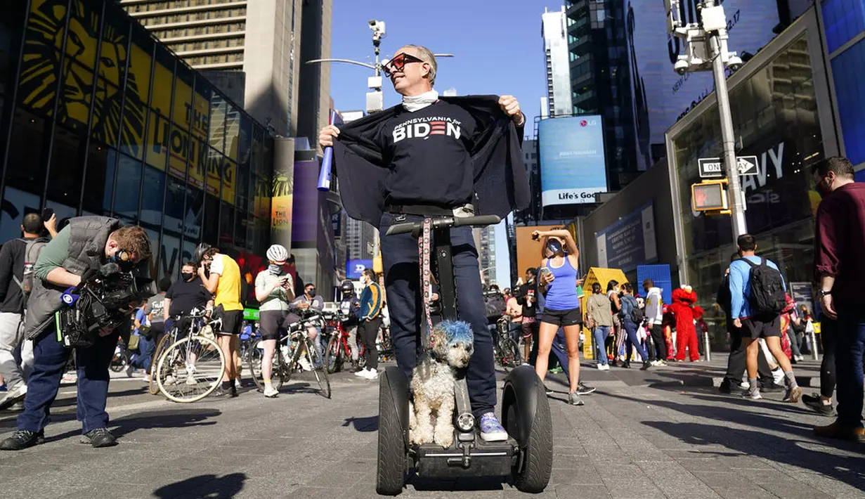 Orang-orang merayakan kemenangan Joe Biden dalam Pilpres AS 2020 di Times Square, New York, Amerika Serikat, Sabtu (7/11/2020). Calon presiden dari Partai Demokrat tersebut keluar sebagai pemenang dan akan menjadi presiden AS ke-46. (AP Photo/Seth Wenig)