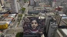 Sebuah mural raksasa karya seniman yang dikenal sebagai BIP, dipajang di dinding bangunan di Sao Paulo, Brasil, Rabu (29/9/2021). Para seniman mural papan atas dikerahkan membuat lukisan raksasa karya terbaik mereka untuk berpartisipasi dalam festival selama seminggu. (AP Photo/Andre Penner)
