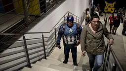 Seorang cosplayer berpakaian seperti karakter Marvel Captain America berdiri  di tangga selama International Comic Con di Kyalami Race Course, Johannesburg, Afrika Selatan (14/9). Comic Con digelar pada tahun 1970. (AFP Photo/Marco Longari)