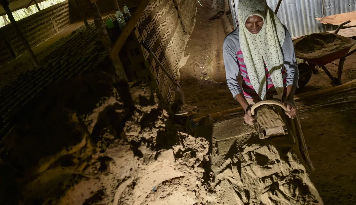 Seorang perempuan bekerja di sebuah pabrik batu bata di pinggiran Kajhu, Provinsi Aceh (18/11/2020). (AFP/Chaideer Mahyuddin)