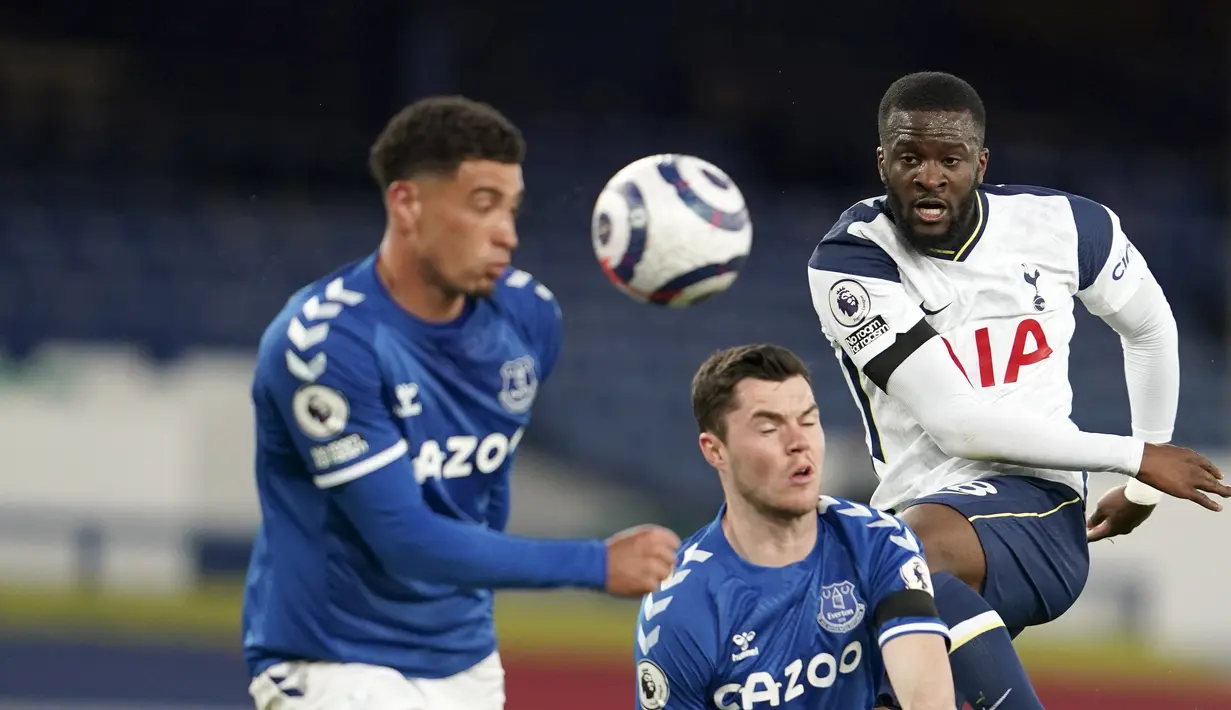 Gelandang Tottenham Hotspur, Tanguy Ndombele menembak bola dari kawalan dua pemain Everton pada pertandingan lanjutan Liga Inggris di Goodison Park di Liverpool, Inggris, Sabtu (17/4/2021). Everton bermain imbang atas Tottenham 2-2. (AP Photo/Jon Super, Pool)