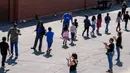 Para staf menyambut siswa setibanya di tempat evakuasi setelah insiden penembakan di SD North Park, San Bernardino di California, Senin (10/4). Dua siswa yang tertembak dalam kondisi kritis dan diterbangkan ke rumah sakit. (AP Photo/Ringo H.W. Chiu)