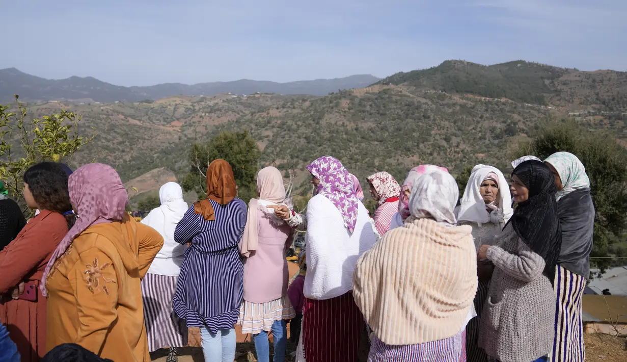 Para wanita menyaksikan dengan prihatin saat pertahanan sipil dan otoritas lokal berusaha menyelamatkan seorang bocah lelaki berusia 5 tahun yang jatuh ke dalam sumur di dekat kota Bab Berred dekat Chefchaouen, Maroko (4/2/2022). (AP Photo/Mosa'ab Elshamy)