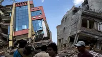 Warga berjalan melewati bangunan yang runtuh pascagempa susulan berkekuatan 7,3 SR melanda Kathmandu, Nepal, Selasa (12/5/2015). Sebelumnya, luka atas gempa dahsyat yang terjadi 25 April lalu di Nepal masih belum terobati. (REUTERS/Athit Perawongmetha)
