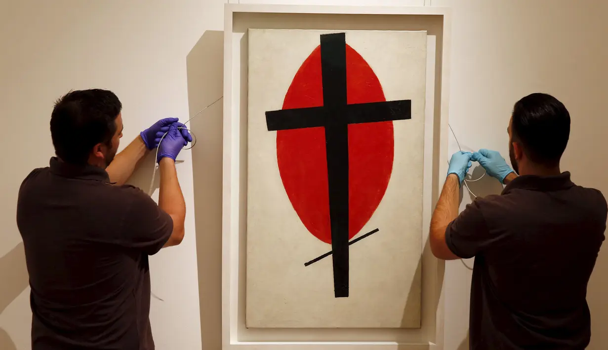 Petugas saat menyiapkan lukisan " Mystic Suprematisme " karya Kasimir Malevich di London, Inggris, Jumat (9/10/2015). Lukisan ini diperkirakan terjual hingga ratusan miliar pada pelelangan di New York 5 November nanti. (REUTERS/Stefan Wermuth)   