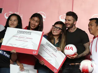 Perwakilan Atlet Asian Games Indonesia swafoto bersama mantan bintang sepak bola Inggris David Beckham dan Menpora Imam Nahrawi pada acara AIA Sepak Bola untuk Negeri di Jakarta, Minggu (25/3). (Liputan6.com/Herman Zakharia)