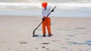 Gambar yang dirilis 4 Oktober 2019 menunjukkan pekerja membersihkan minyak di pantai Pontal de Coruripe di Coruripe, negara bagian Alagoas, Brasil. Tumpahan minyak yang telah mengering sejak beberapa pekan terakhir telah mencemari 132 pantai di kawasan timur laut Brasil. (HO/ADEMAS /AFP)