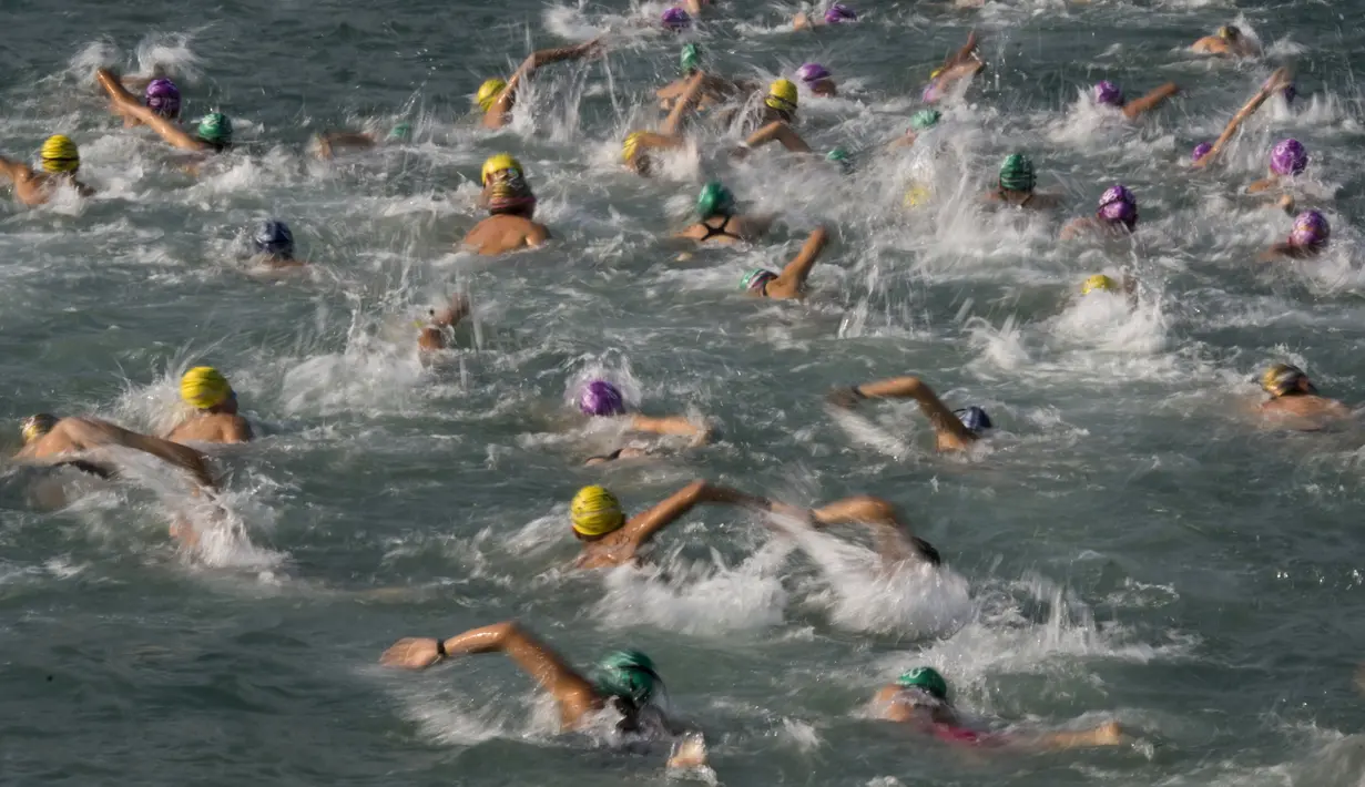 Perenang berkompetisi dalam lomba renang lintas pelabuhan di Hong Kong, Minggu (18/10). 2.500 orang ambil bagian dalam menembus jarak lintasan laut sejauh 1,5 km dari Sam Ka Tsuen Public Pier ke Quarry Bay Park Public Pier. (REUTERS/Tyrone Siu)